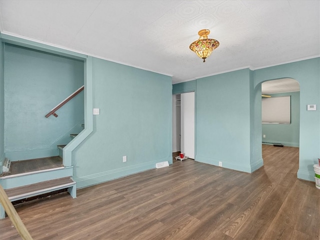 unfurnished living room featuring crown molding, hardwood / wood-style flooring, and a textured ceiling