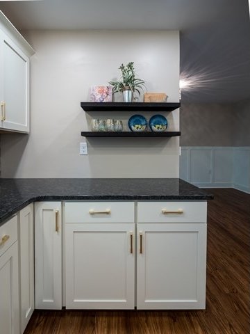 kitchen featuring white cabinetry, dark stone counters, and dark hardwood / wood-style flooring