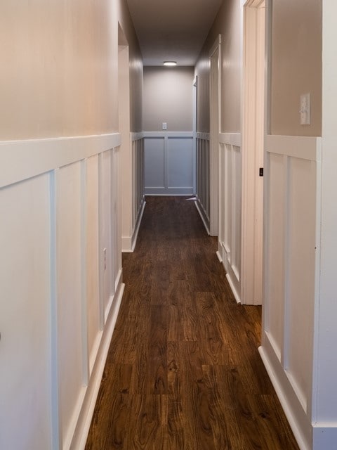 corridor with dark hardwood / wood-style flooring