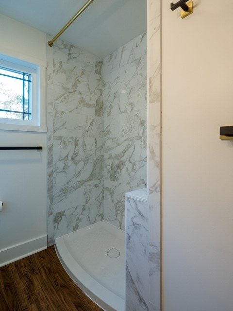 bathroom with hardwood / wood-style floors and tiled shower