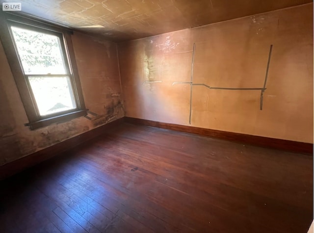 unfurnished room with dark wood-type flooring