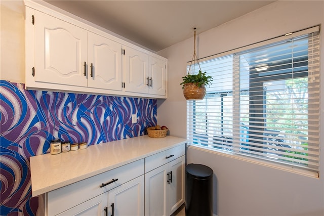 interior space with backsplash and white cabinets