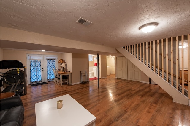 unfurnished living room with french doors, dark hardwood / wood-style floors, and a textured ceiling