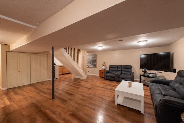 living room with a textured ceiling and hardwood / wood-style flooring