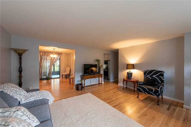 living room featuring hardwood / wood-style flooring and an inviting chandelier