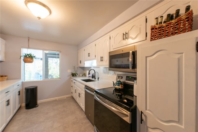 kitchen with stainless steel appliances, decorative backsplash, sink, and white cabinets