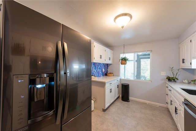 kitchen with sink, dishwasher, white cabinets, and refrigerator with ice dispenser