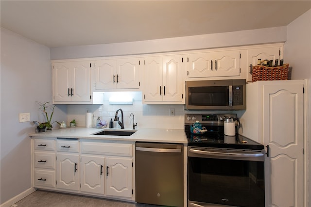 kitchen with white cabinetry, backsplash, stainless steel appliances, and sink