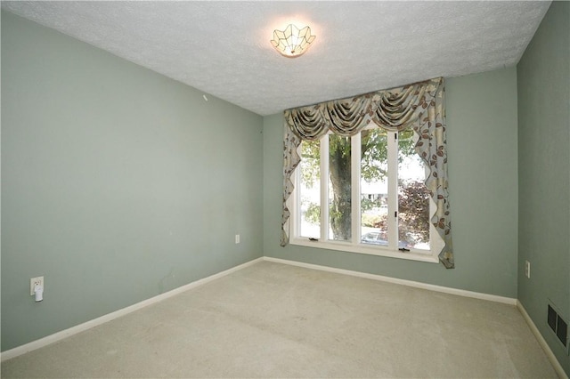 carpeted spare room with a textured ceiling