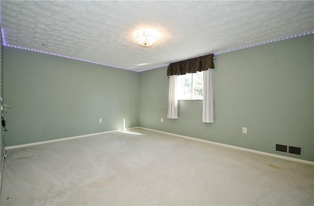 carpeted empty room with a textured ceiling