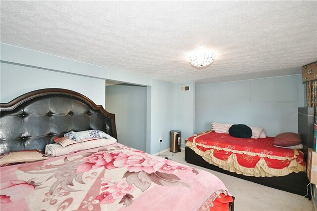 bedroom featuring carpet and a textured ceiling