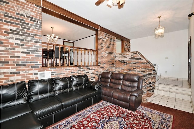 tiled living room with brick wall and an inviting chandelier