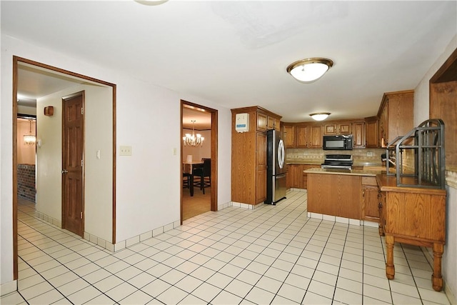 kitchen featuring a chandelier, appliances with stainless steel finishes, backsplash, and kitchen peninsula