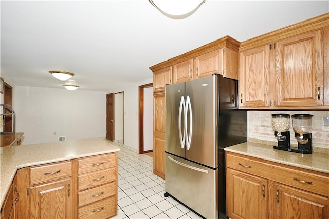 kitchen featuring decorative backsplash, stainless steel fridge, and light tile patterned floors