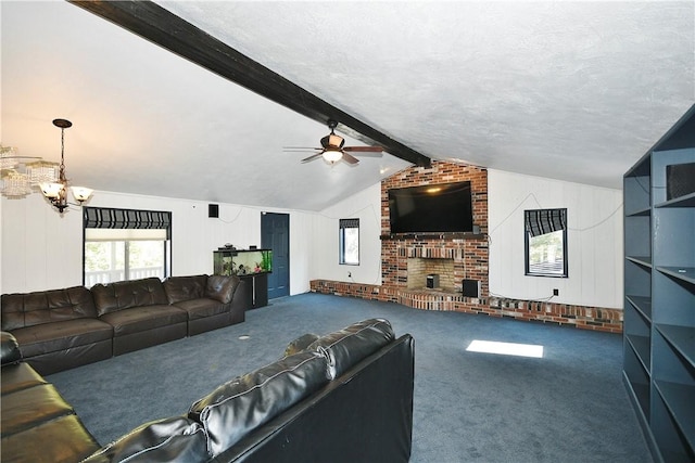 living room with ceiling fan with notable chandelier, carpet floors, a textured ceiling, a fireplace, and vaulted ceiling with beams