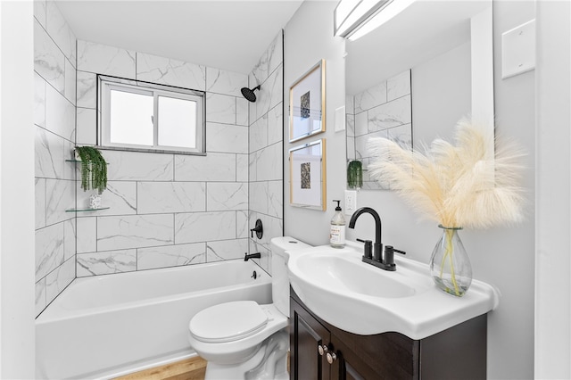 full bathroom with vanity, tiled shower / bath, hardwood / wood-style flooring, and toilet