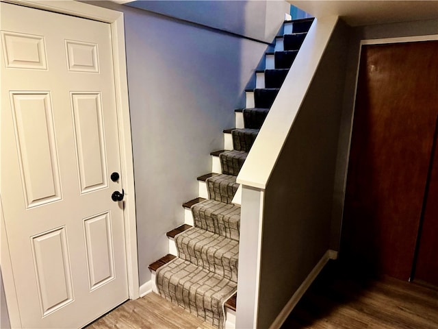 staircase with hardwood / wood-style flooring