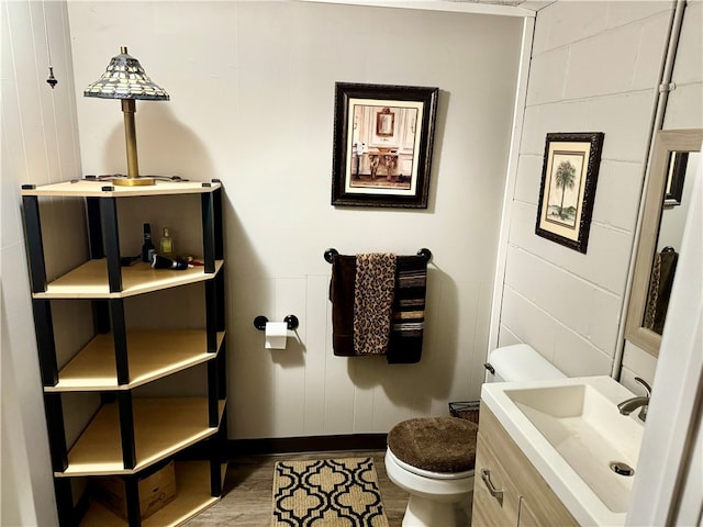 bathroom with toilet, wood-type flooring, and vanity