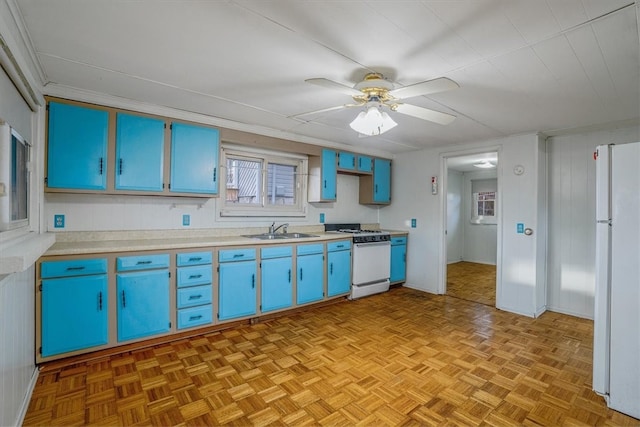 kitchen with white appliances, sink, blue cabinets, light parquet floors, and ceiling fan