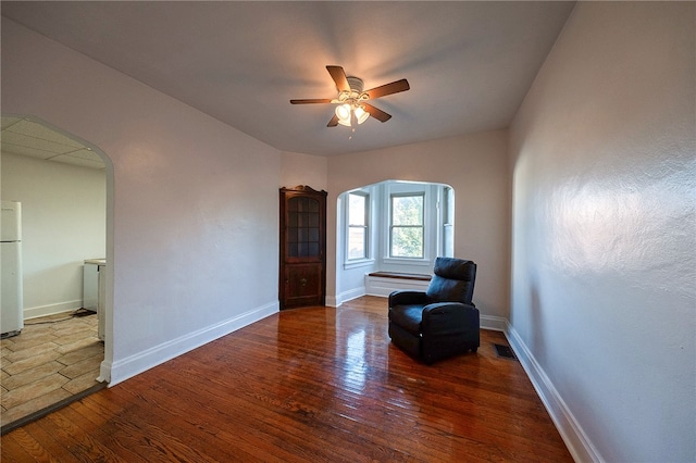 living area with hardwood / wood-style floors and ceiling fan