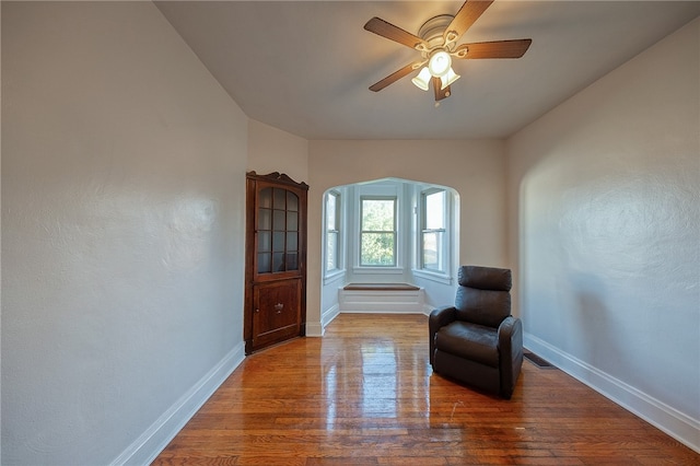 sitting room with hardwood / wood-style flooring and ceiling fan