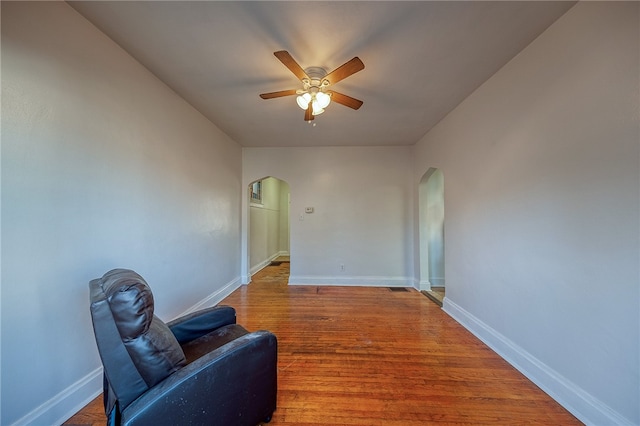 living area featuring hardwood / wood-style flooring and ceiling fan