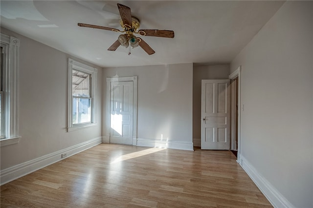 empty room with ceiling fan and light hardwood / wood-style flooring