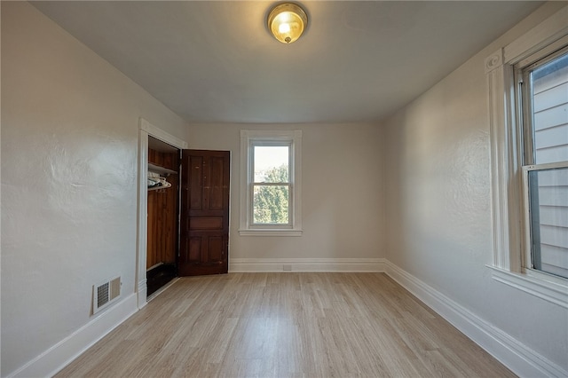 unfurnished bedroom with light hardwood / wood-style flooring and a closet