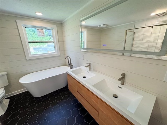 full bathroom with plus walk in shower, tile patterned floors, sink, toilet, and ornamental molding