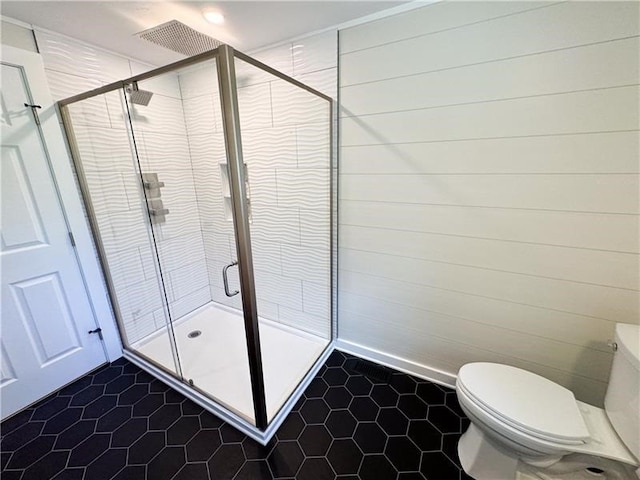 bathroom with tile patterned flooring, an enclosed shower, and toilet