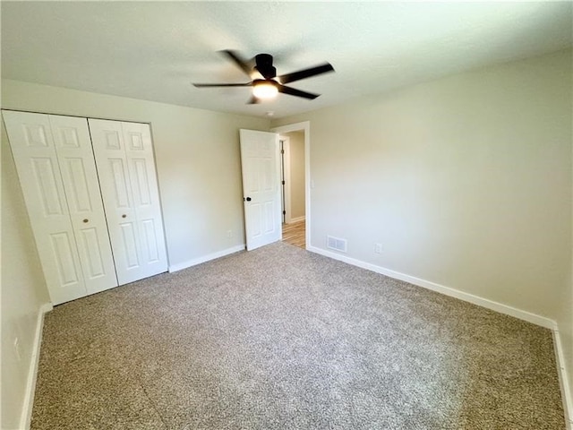 unfurnished bedroom featuring carpet flooring, ceiling fan, and a closet