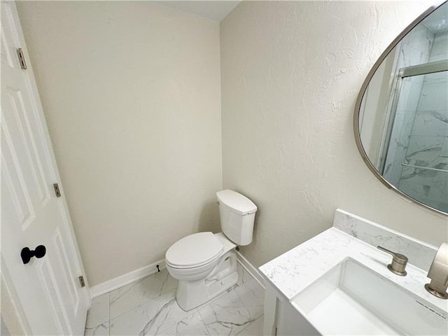 bathroom featuring vanity, toilet, and a shower with door