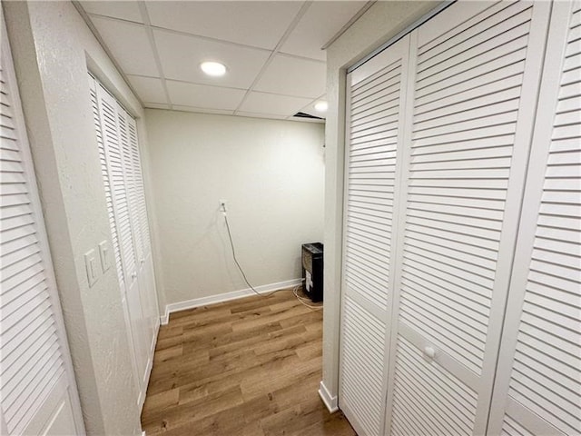 hallway with hardwood / wood-style flooring and a drop ceiling