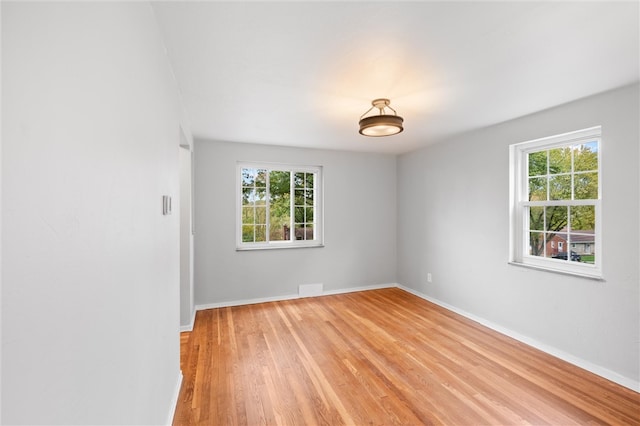 unfurnished room with light hardwood / wood-style floors and a healthy amount of sunlight