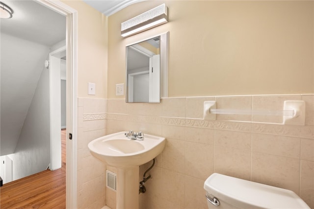 bathroom featuring toilet, hardwood / wood-style flooring, sink, and tile walls