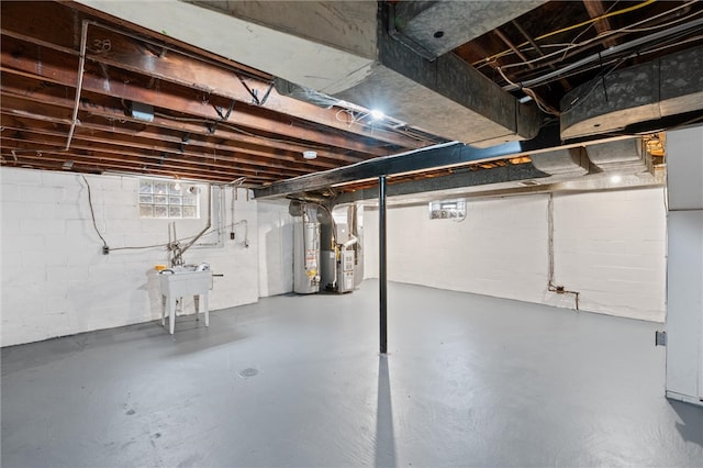 basement featuring sink, gas water heater, and heating unit