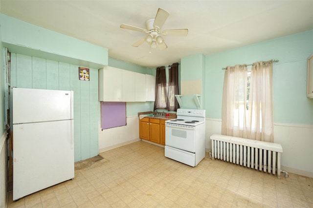 kitchen with ceiling fan, sink, radiator, and white appliances