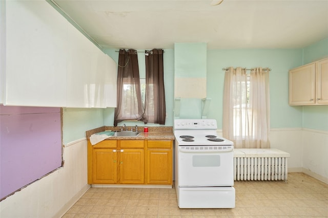 kitchen with white electric stove, sink, and radiator