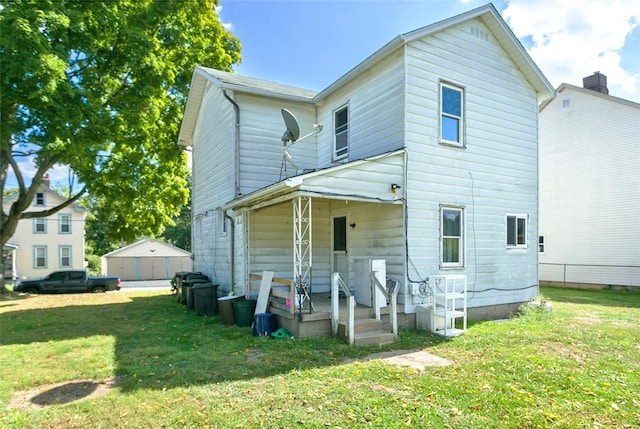 rear view of house with an outbuilding, a garage, and a lawn