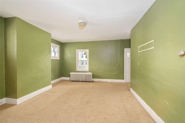 carpeted spare room featuring radiator heating unit