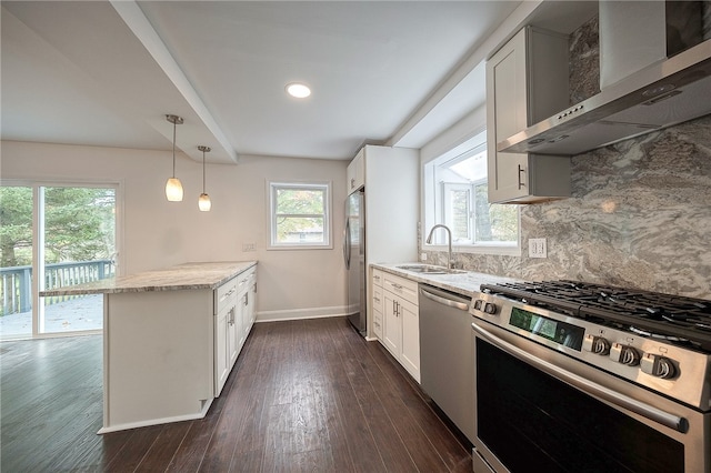 kitchen with wall chimney exhaust hood, white cabinetry, light stone counters, and stainless steel appliances