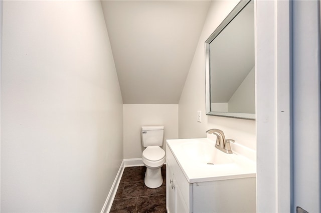 bathroom featuring vanity, toilet, lofted ceiling, and tile patterned flooring