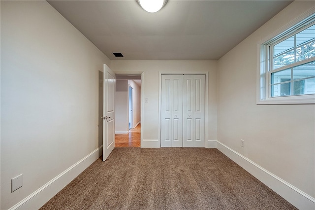 unfurnished bedroom with a closet and carpet flooring