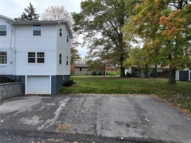 view of property exterior featuring a lawn and a garage