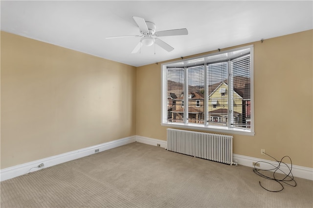 unfurnished room featuring radiator, ceiling fan, and light colored carpet