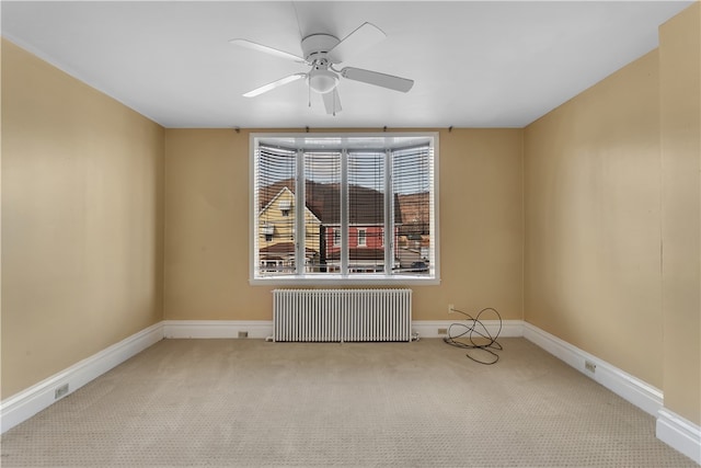 carpeted spare room with ceiling fan and radiator heating unit