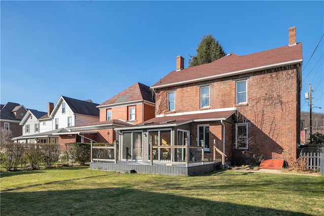 back of house with a lawn and a sunroom