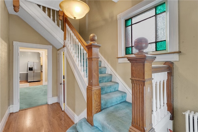 staircase featuring radiator and wood-type flooring