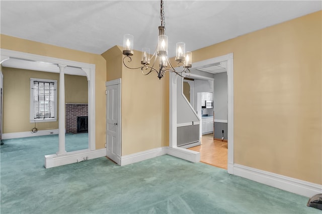 unfurnished dining area with a notable chandelier, a brick fireplace, and carpet floors