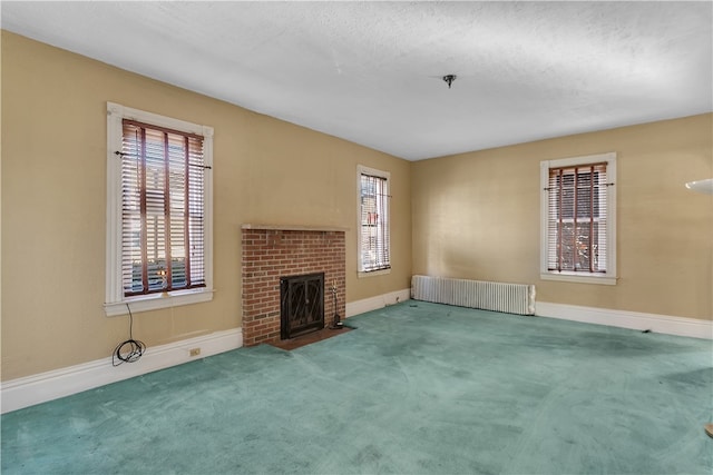 unfurnished living room with radiator, carpet, and a wealth of natural light